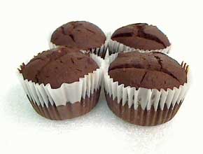 Four chocolate muffins in white paper cups.