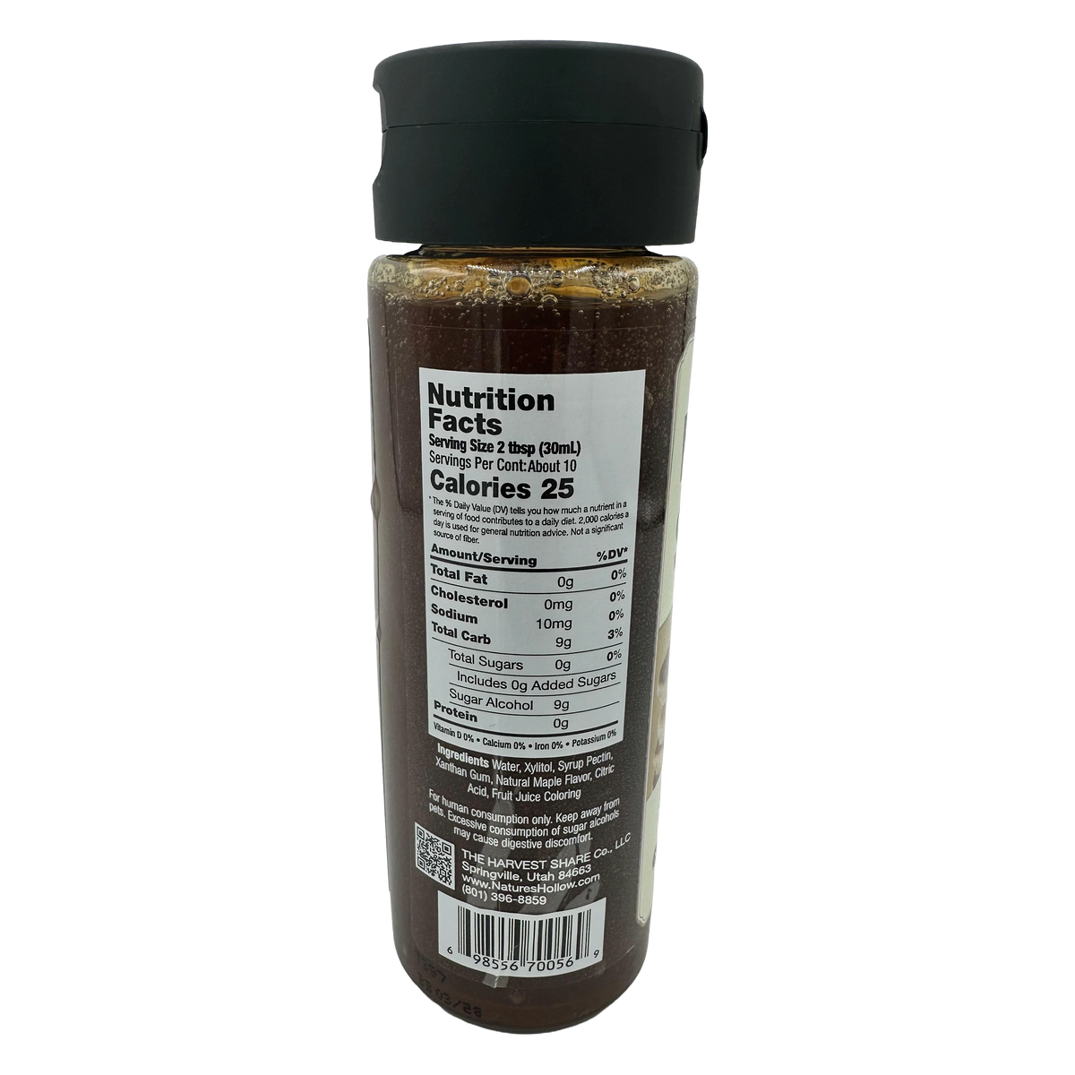 A clear bottle with a black cap displays nutrition facts, including serving size, calories, and ingredients, for a syrup product labeled with details on sugars and other nutritional information.
