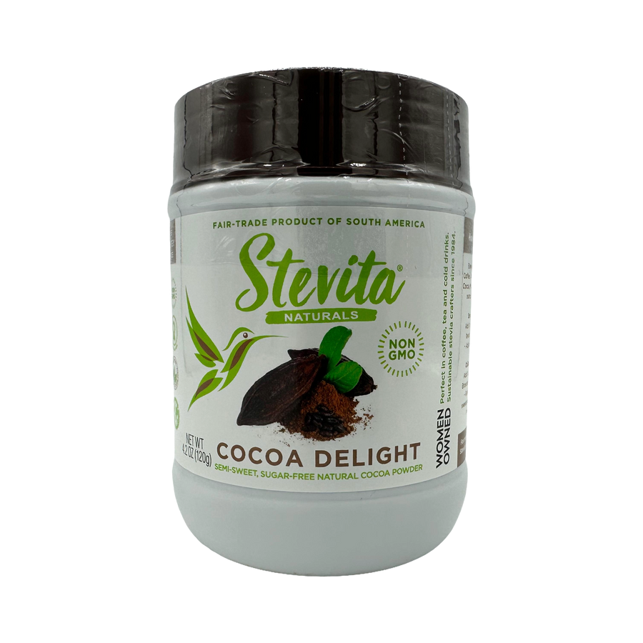 A white container of Stevita Naturals Cocoa Delight cocoa powder features a green logo, a hummingbird graphic, and labels indicating it's fair-trade, non-GMO, and sugar-free.
