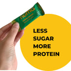 Hand holding a Numa Creamy Coconut taffy wrapper beside a product comparison graphic