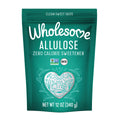 A teal pouch labeled "Wholesome Allulose" features the text "Zero Calorie Sweetener," decorative heart and leaf designs, and certification logos for Non-GMO and Keto, indicating a clean sweet taste product.