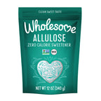 A teal pouch labeled "Wholesome Allulose" features the text "Zero Calorie Sweetener," decorative heart and leaf designs, and certification logos for Non-GMO and Keto, indicating a clean sweet taste product.