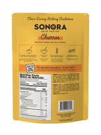 A yellow packaging for Sonora Keto Pantry Churros mix displays preparation instructions, nutritional information, and a QR code for detailed guidance, emphasizing clean living baking traditions.