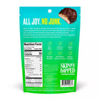 A teal bag of Skinny Dipped coconut almond bites features a playful slogan, nutrition facts, and highlights like gluten-free and no artificial colors, promoting a fun and healthy snack option.