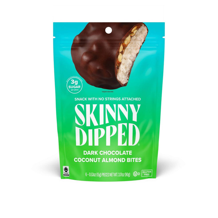 A bright teal and green package of Skinny Dipped Dark Chocolate Coconut Almond Bites features a bite taken out of the chocolate-covered snack, highlighting its ingredients and low sugar content.