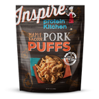 A bag of Inspire Protein Kitchen Maple Bacon Pork Puffs features a bowl of crispy pork puffs on a colorful plate, with a cartoon chef illustration and the product name prominently displayed.