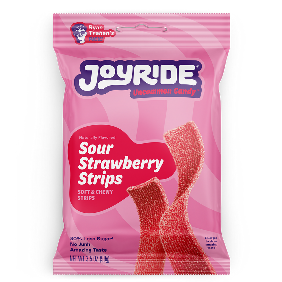 A pink package of Joyride Sour Strawberry Strips features the product name prominently, with a description of being soft and chewy, and highlights that it contains 80% less sugar.