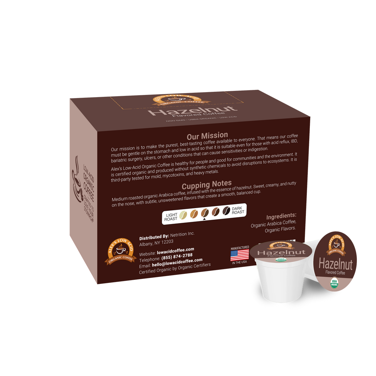 A brown coffee box labeled "Hazelnut" displays a mission statement and cupping notes, alongside a single serve coffee pod, emphasizing organic and low-acid features for sensitive drinkers.