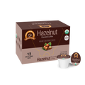 A brown box of organic hazelnut flavored coffee with a logo and information about its low acidity, containing 12 single-serve cups, is displayed against a plain background.