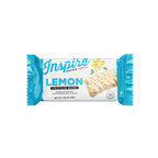A blue and white wrapper displays a lemon protein bar, labeled "Inspire Lemon Protein Bars," featuring a drizzle of icing and highlighting its 12 grams of protein per serving.