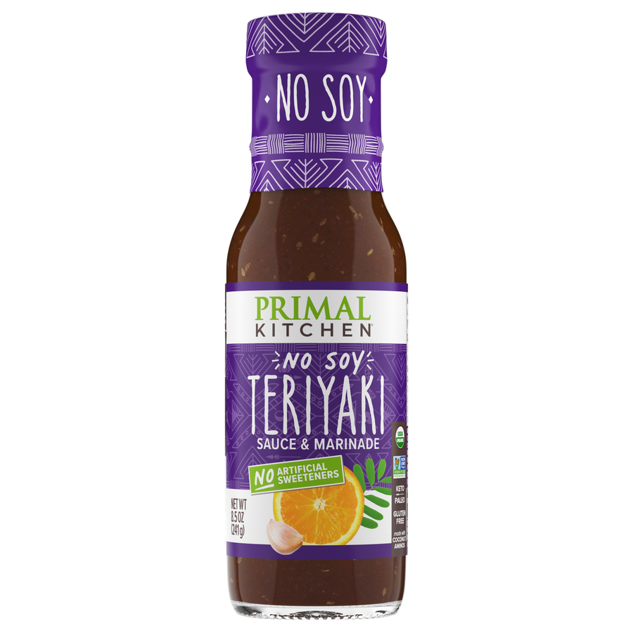 A bottle of Primal Kitchen No Soy Teriyaki Sauce and Marinade features a purple label with white text, highlighting its soy-free and no artificial sweeteners attributes, alongside an orange and garlic illustration.