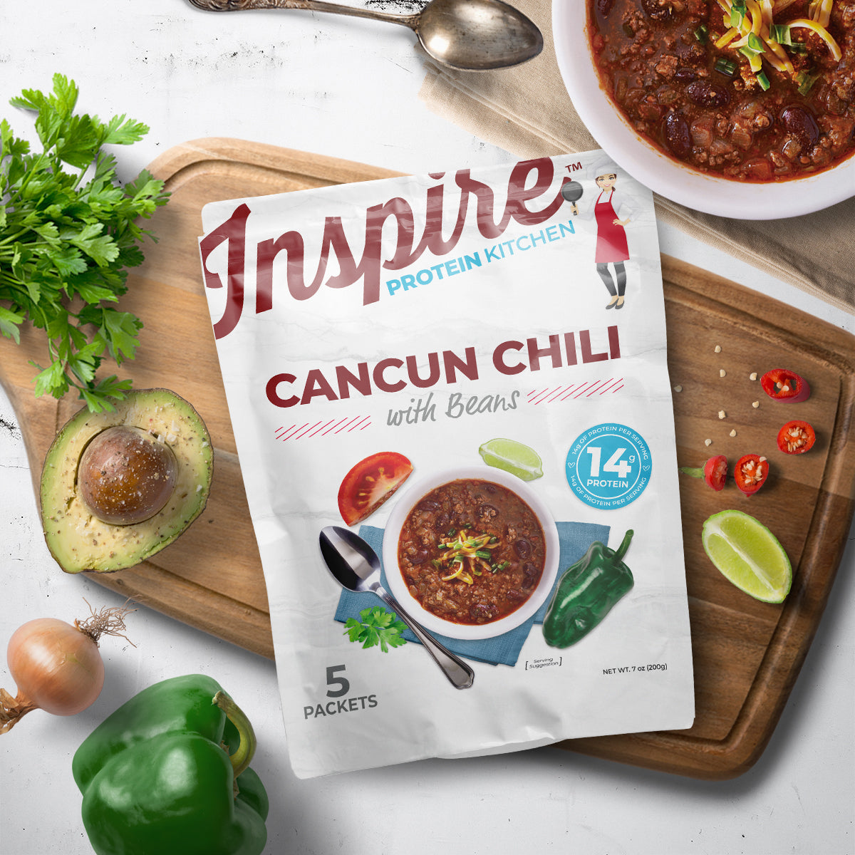 Five-packet pouch of Inspire Cancun Chili with Beans beside prepared chili.
