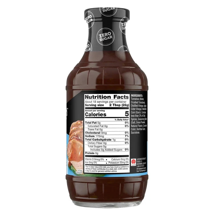 A dark brown bottle of zero sugar barbecue sauce displays nutrition facts, including serving size and calorie count, with a label featuring ingredients and a photo of cooked meat.