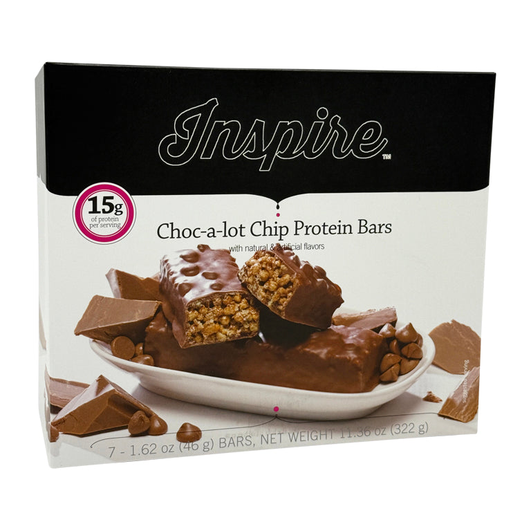 A box of Inspire Choc-a-lot Chip Protein Bars displays a partially broken bar revealing its chewy texture, surrounded by chocolate pieces and chips on a white plate.