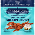 A teal package of Cinnabon 100% Uncured Bacon Jerky features crispy bacon strips and a cinnamon roll with icing, highlighting its gluten-free and no added MSG attributes.