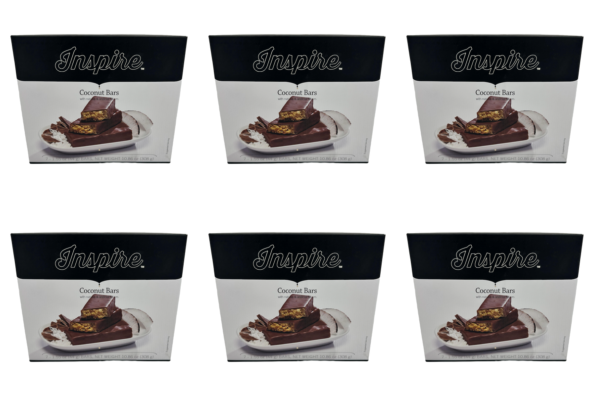 A collection of six boxes of "Inspire" Coconut Bars, each featuring a plate with chocolate-covered coconut bars and coconut slices, highlighting the product's branding and flavor.