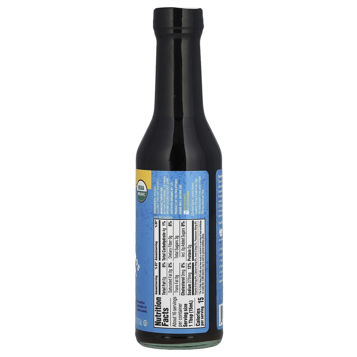 A black glass bottle of organic sauce displays a blue label with nutrition facts and ingredients, positioned upright against a plain background.