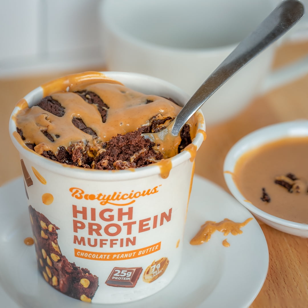 Prepared Bootylicious Chocolate Peanut Butter muffin cup with peanut butter topping and spoon