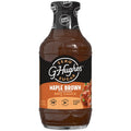 A clear bottle of G. Hughes Maple Brown flavored BBQ sauce, labeled as zero sugar, featuring a black and orange design with nutritional information, sits against a plain background.
