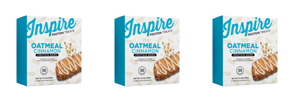 Three boxes of Inspire Oatmeal Cinnamon protein bars are displayed, each featuring a cookie image and text highlighting the flavor, protein content, and natural ingredients.