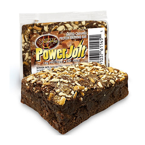 A Scrumptious PowerJolt Salted Caramel Protein Brownie with toppings beside its wrapper.