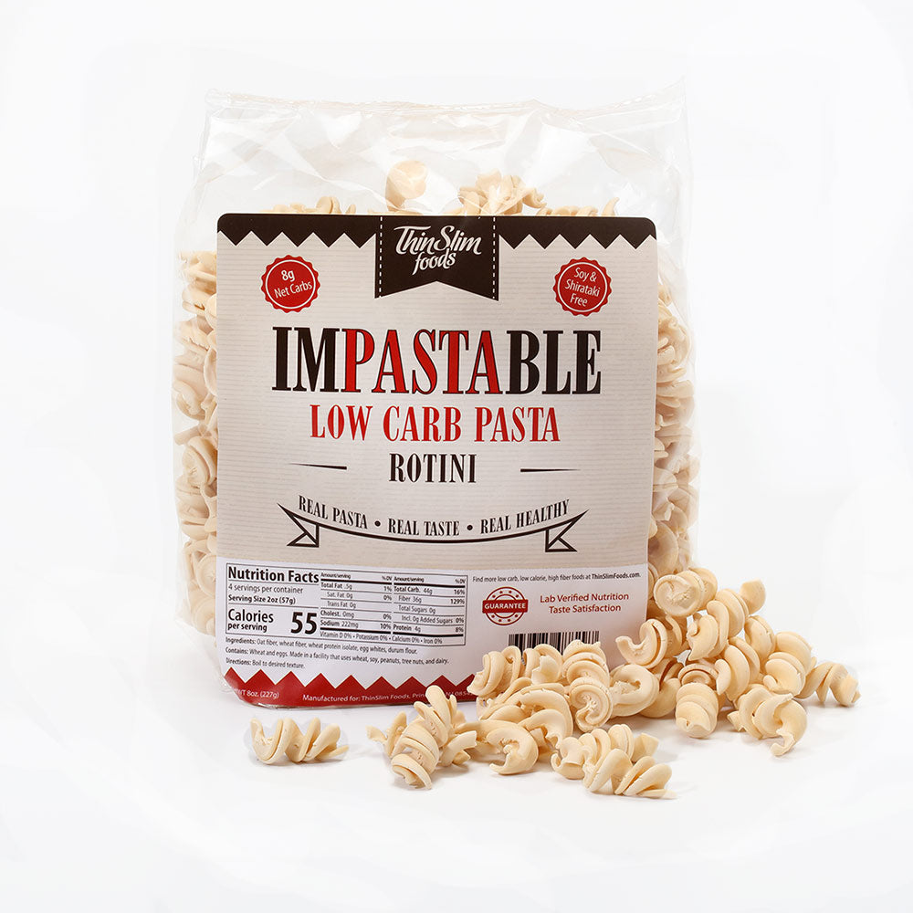 A bag of Impastable Rotini with dry spiral pasta in front.