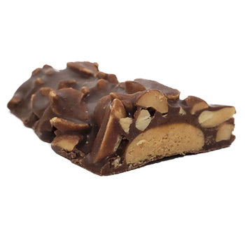 A Keto Wise Chocolate Peanut Blast bar cut open to show its center beneath the chocolate and peanuts.