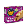 A colorful package of Siete Grain Free Taco Shells prominently displays the brand logo, highlights made with avocado oil, and shows a taco filled with meat and toppings, indicating a gluten-free product.