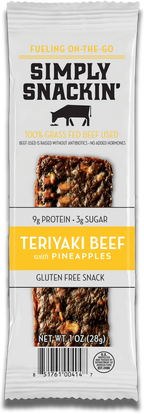 A packaged snack featuring a teriyaki beef jerky bar with pineapple pieces, labeled "Simply Snackin'," highlighting its gluten-free and grass-fed beef qualities.