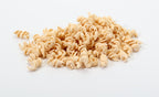 Uncooked rotini pasta spirals on a white background