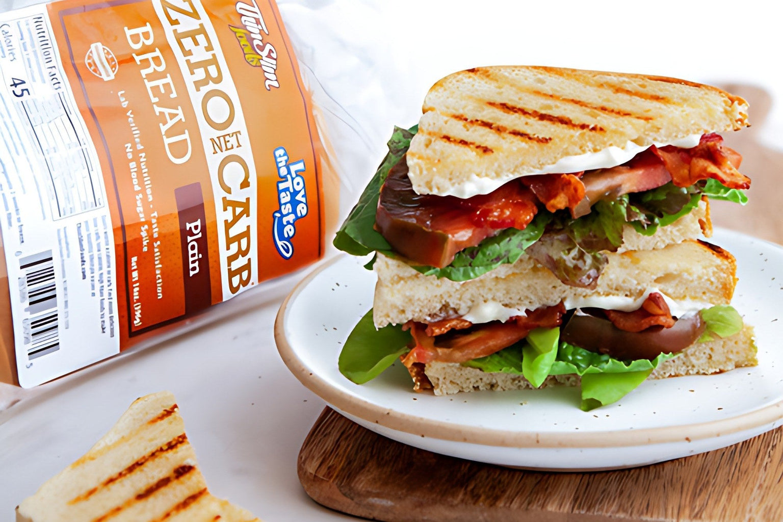 Sliced ThinSlim Foods bread on a board beside a toasted sandwich