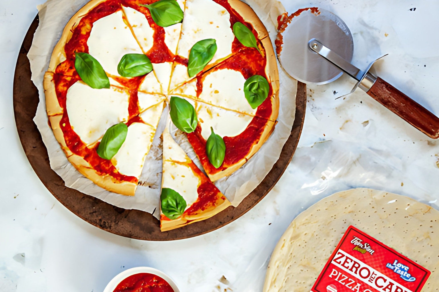 A margherita pizza on ThinSlim Foods Zero Net Carb Pizza Crust beside the package